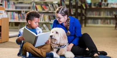 Child Reading With A Dog