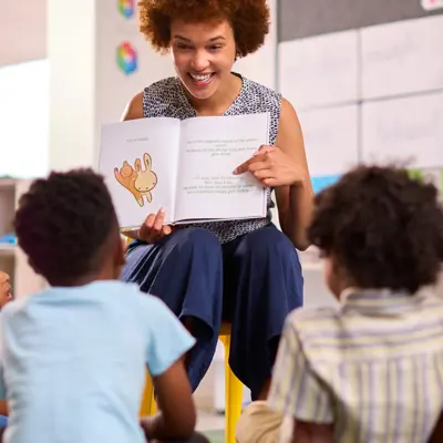 Woman reading a story to children in a circle